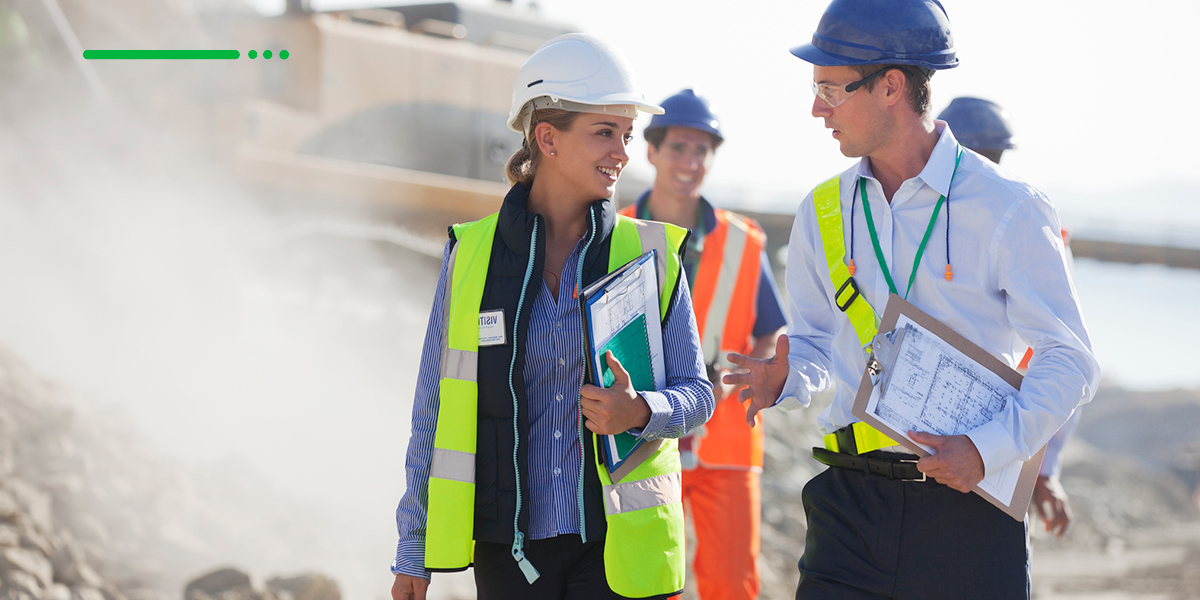 Two construction workers discussing their current project while standing on the job site